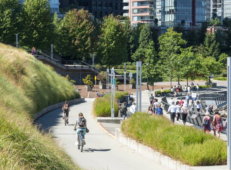 Cyclists and people travel along the Coal Harbour seawall in Vancouver, British Columbia.