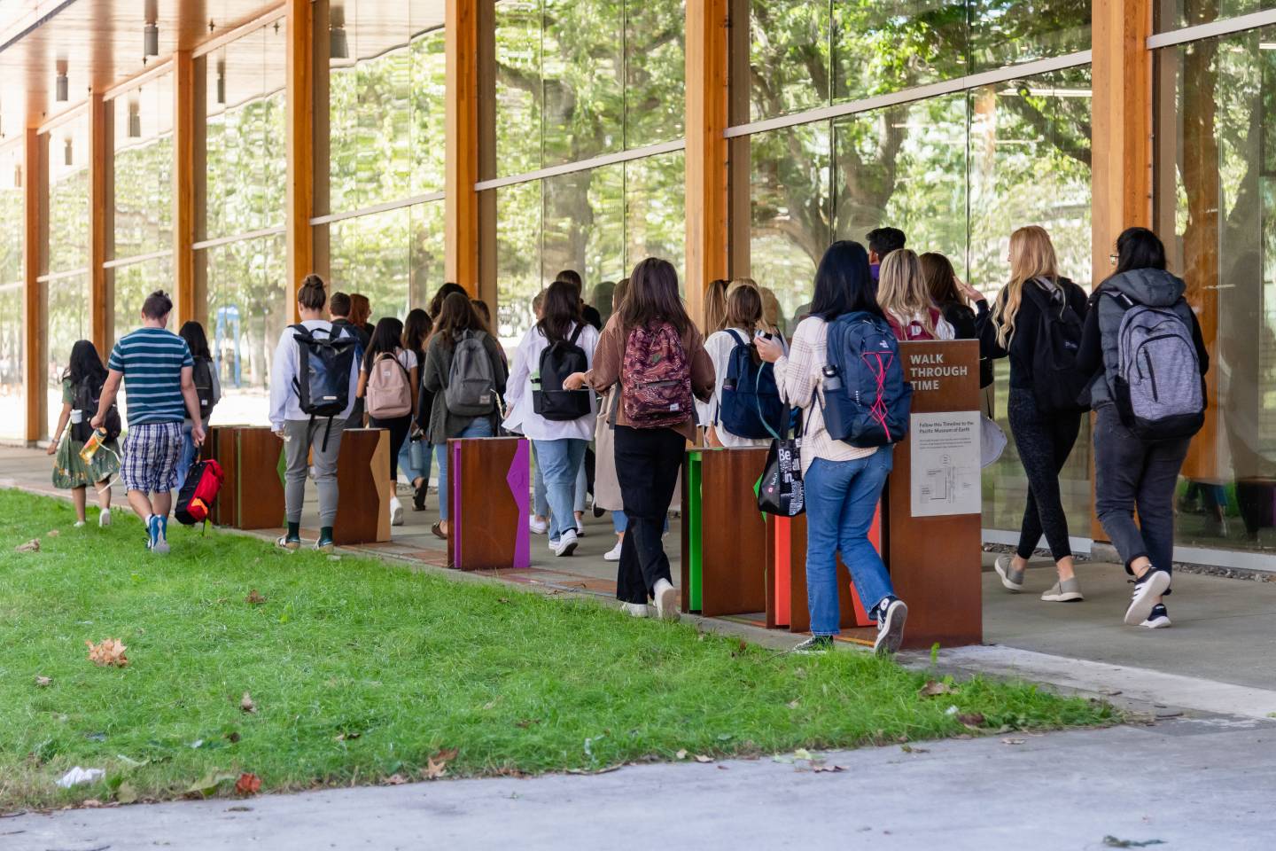 Students walking past exhibit