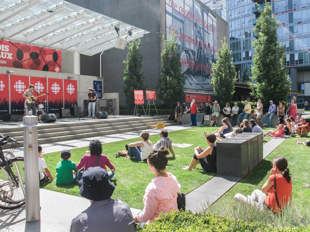 People listen to a live music performance on the plaza lawn.