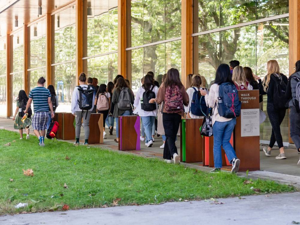 Photo of students walking by iterpretive signage.