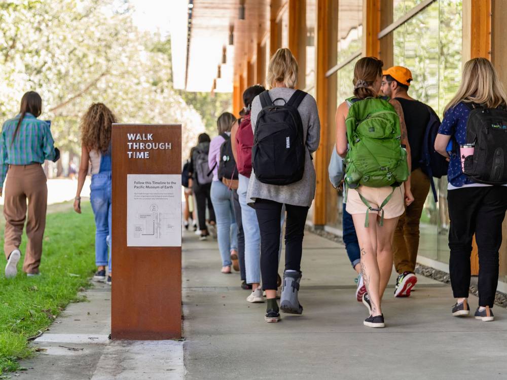 photo of students walking by signage.