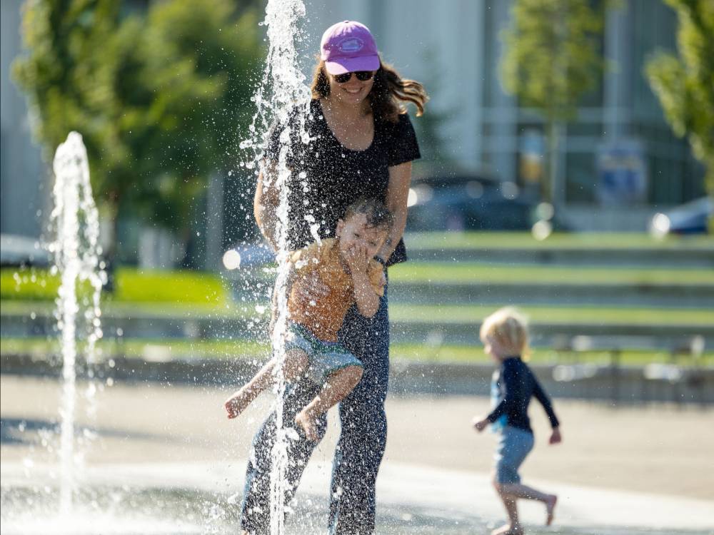 photo of people playing in water fountain in plaza.