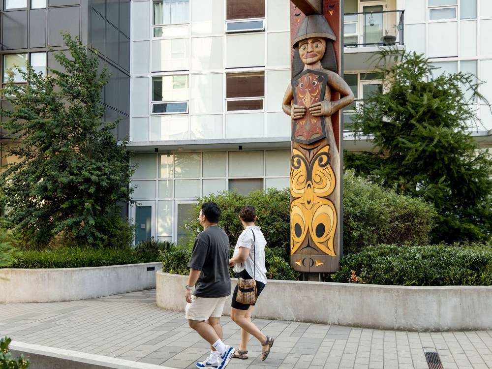 A couple walking near welcome pole.