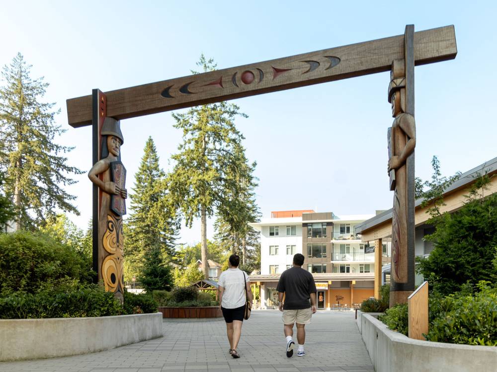 A couple walking under welcome pole.