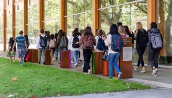 Photo of students walking past exhibit.