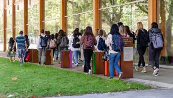 Students walking past exhibit