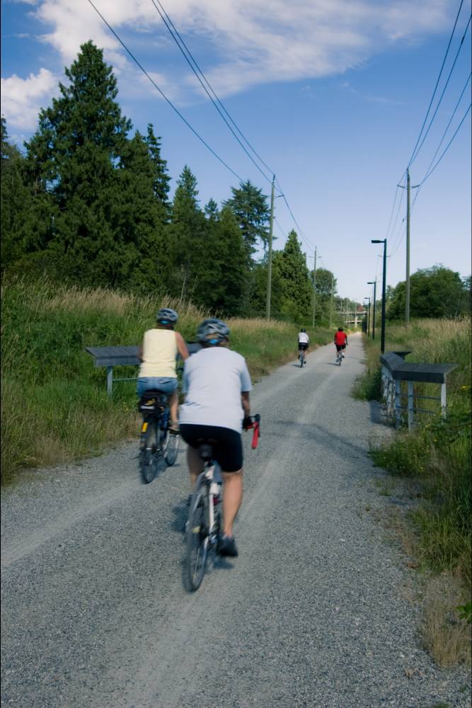 People biking on the greenway near Burnaby Lake.