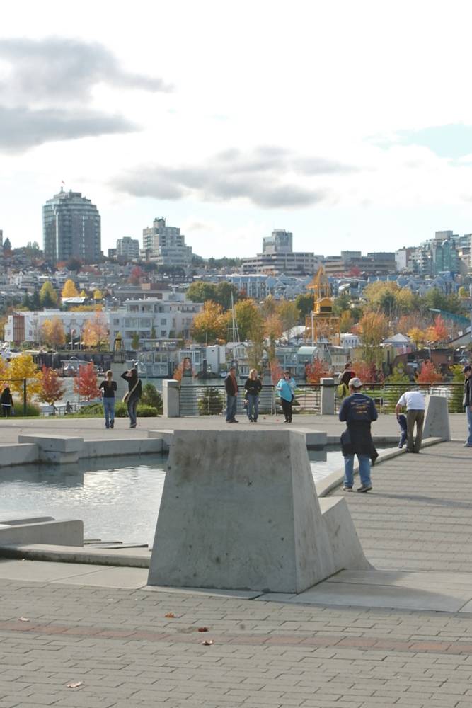 People walk around the park fountain.
