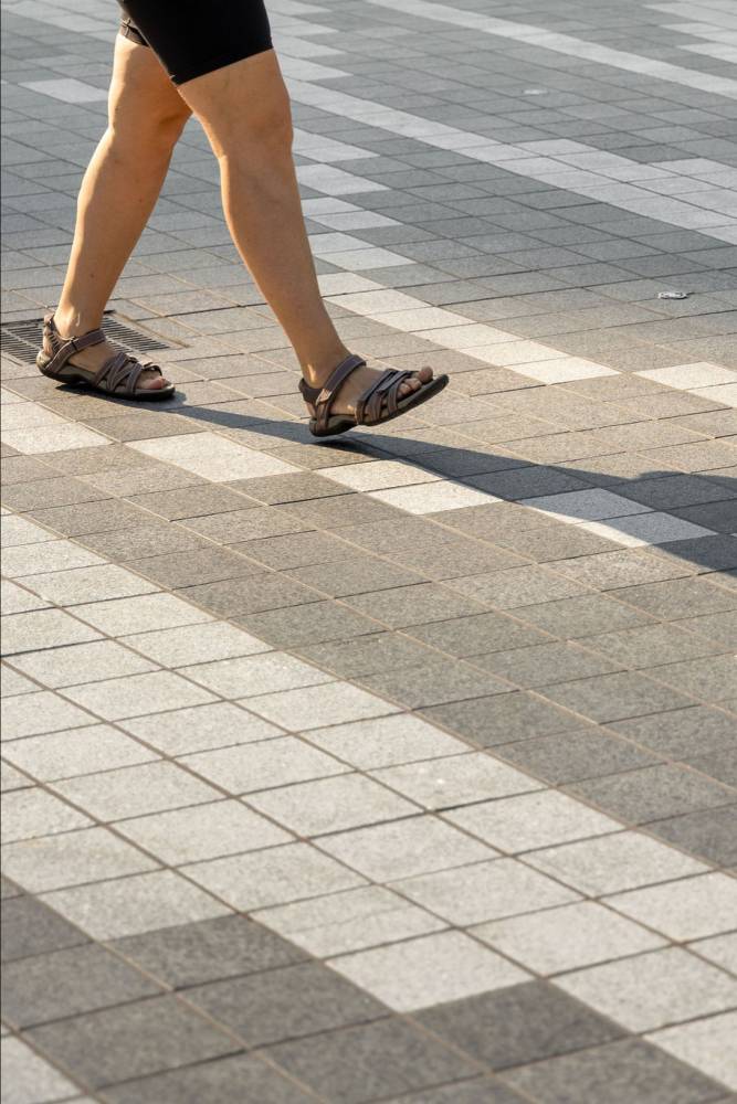 photo of person walking on unique paving patterns.