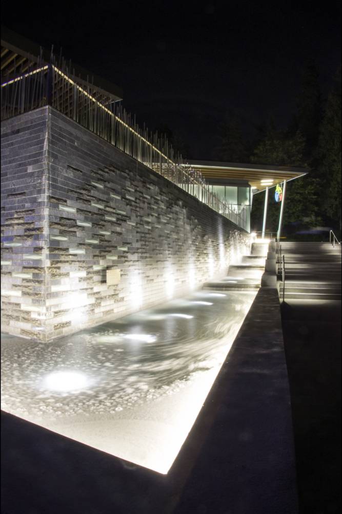 Closeup of the water feature lit up at night.