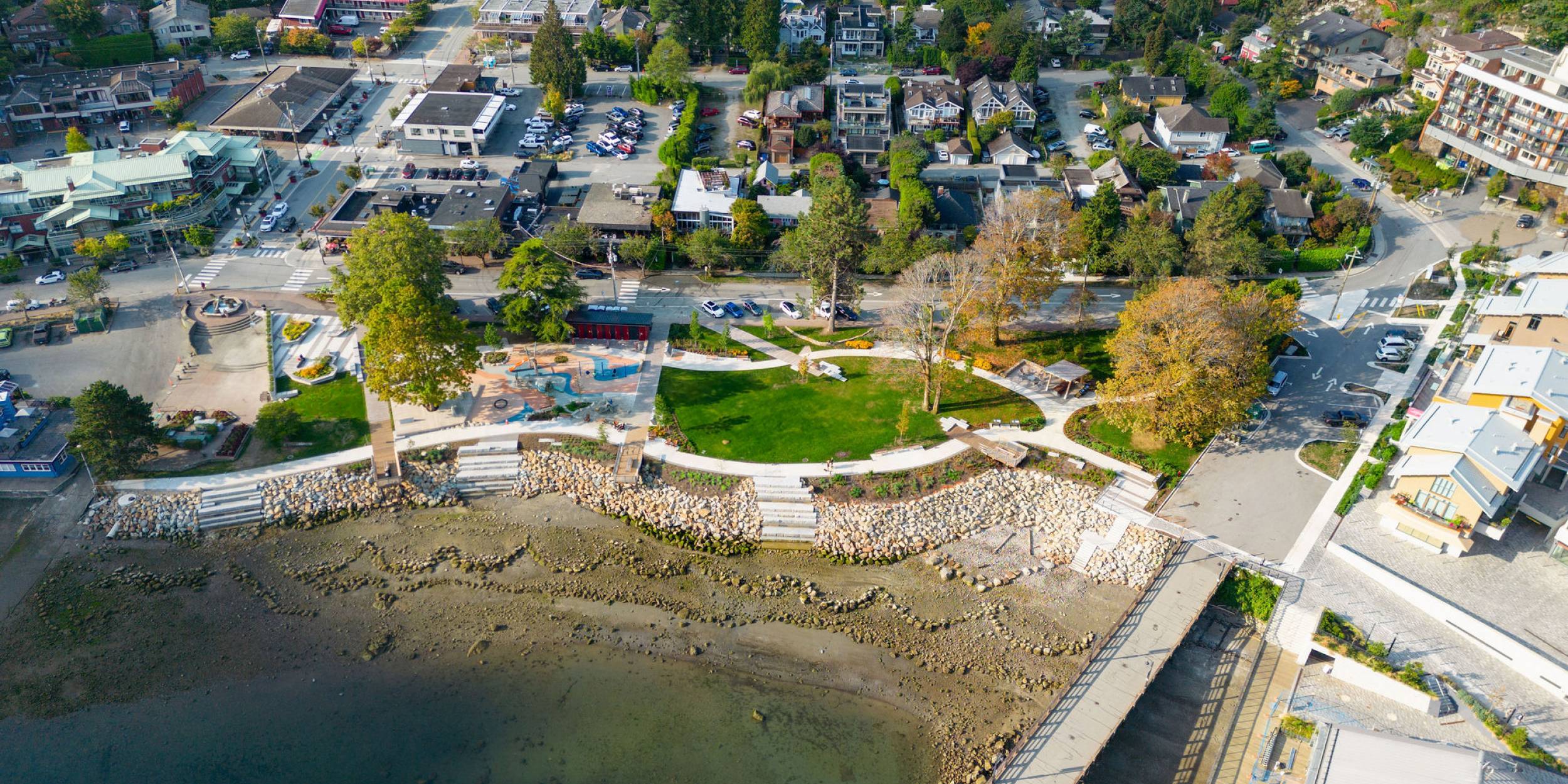 Aerial view of Horseshoe Bay Waterfront Park, showing the rip-rap shoreline, updated playground and open lawn space.