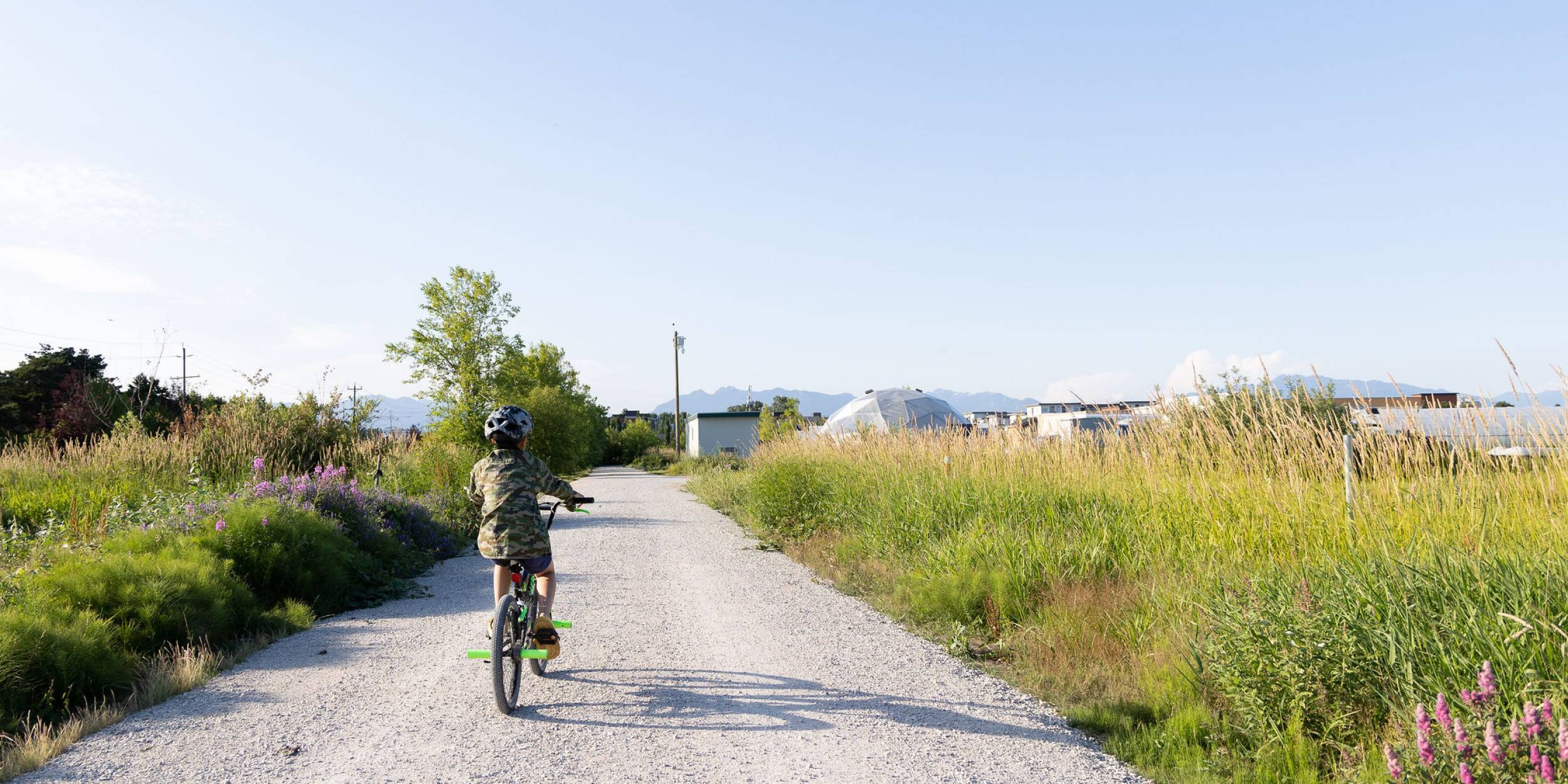 A child bikes along one of the gravel trails in Garden City Lands in Richmond
