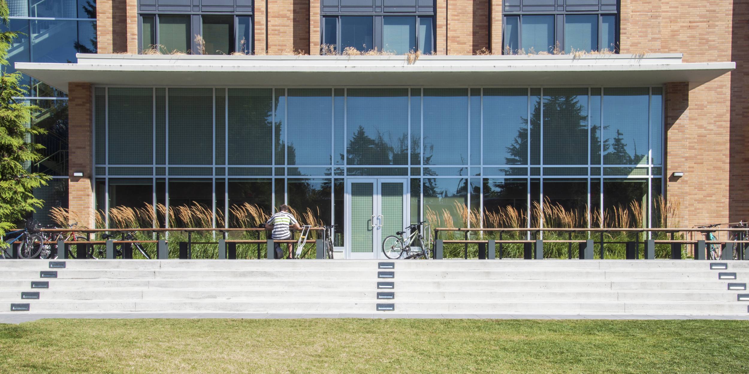A student sits on one of the benches outside of the student residence.