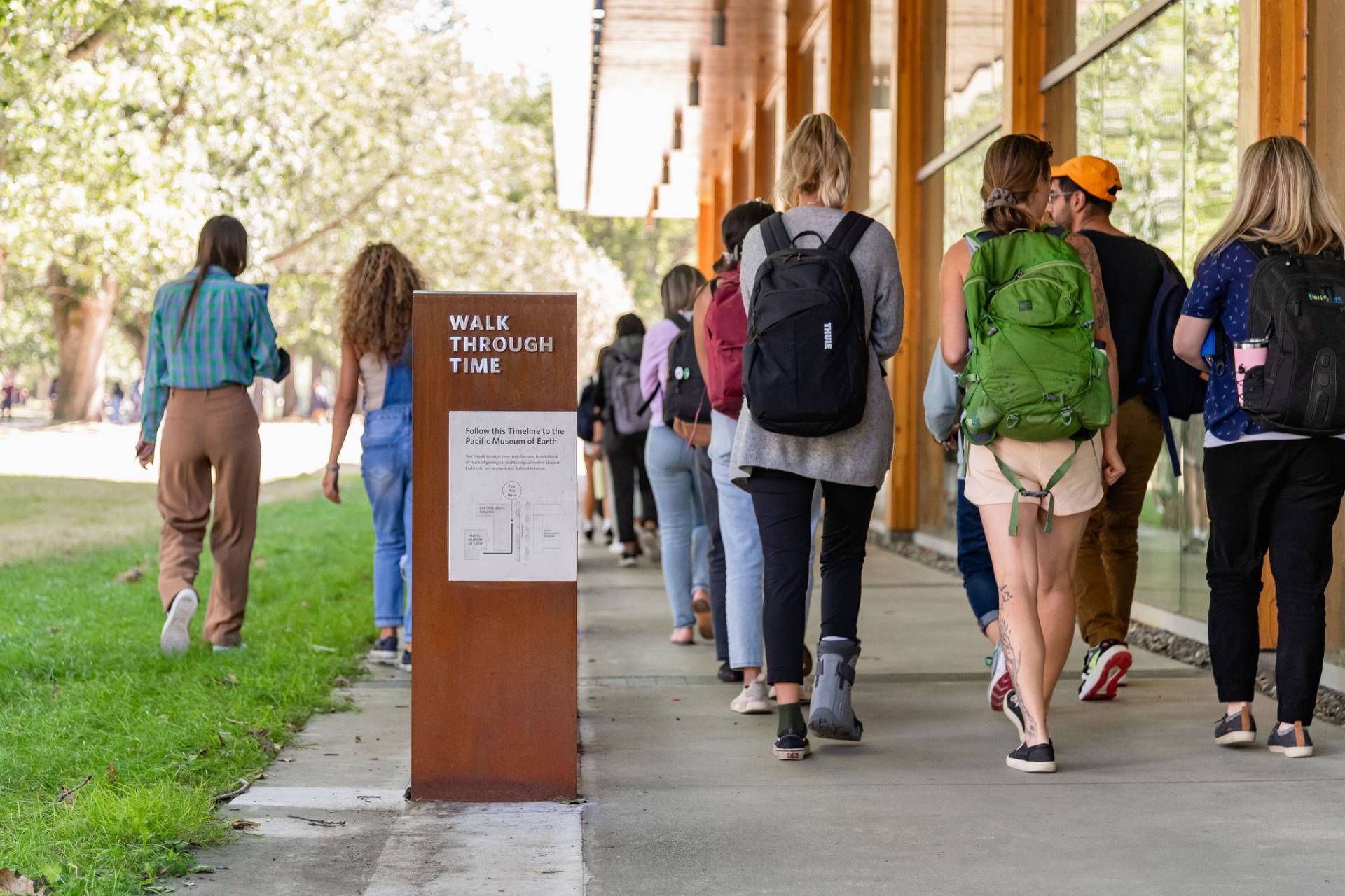 Photo of students walking past exhibit.