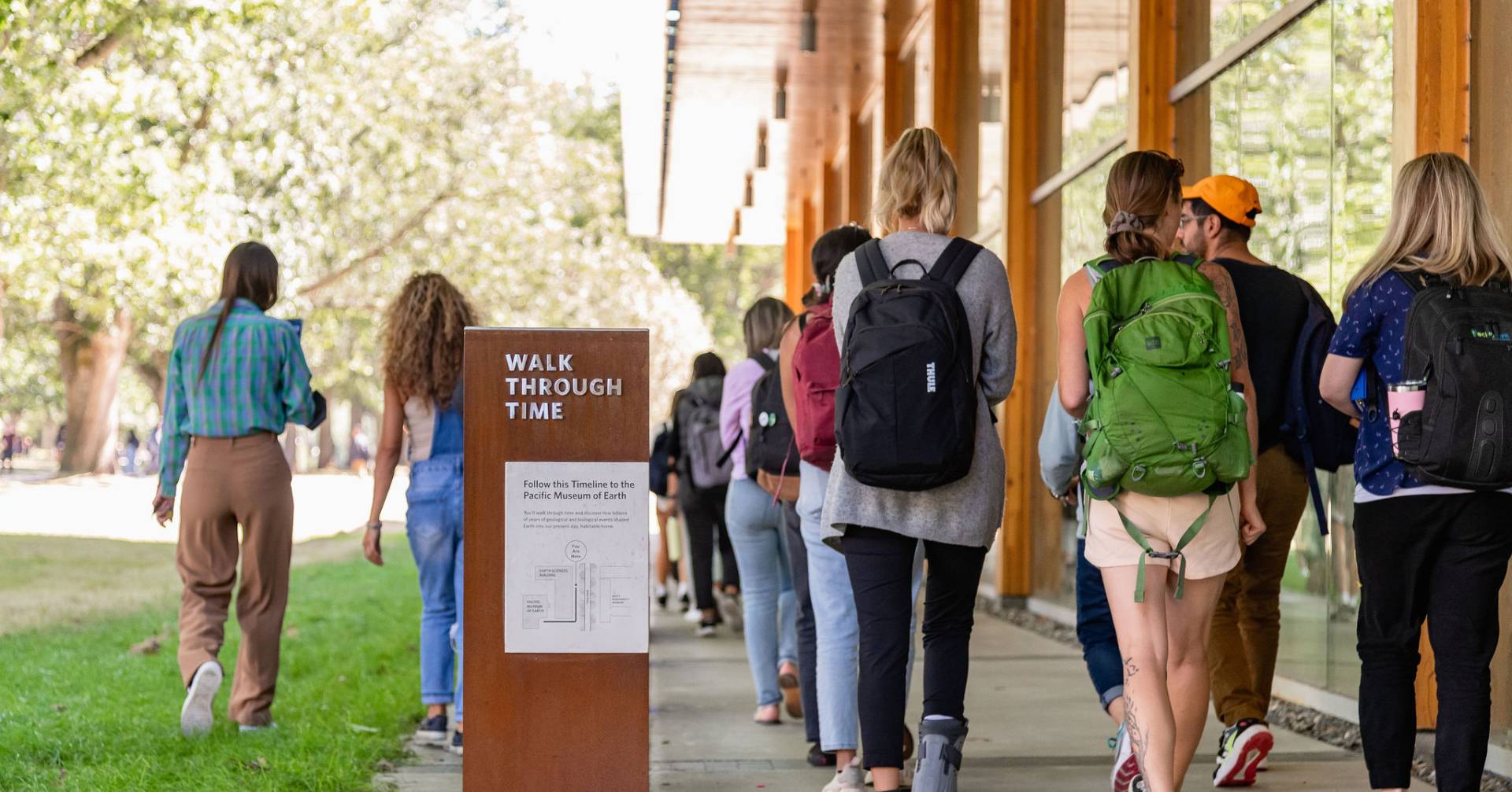 Students walk past interpretive sign at UBC