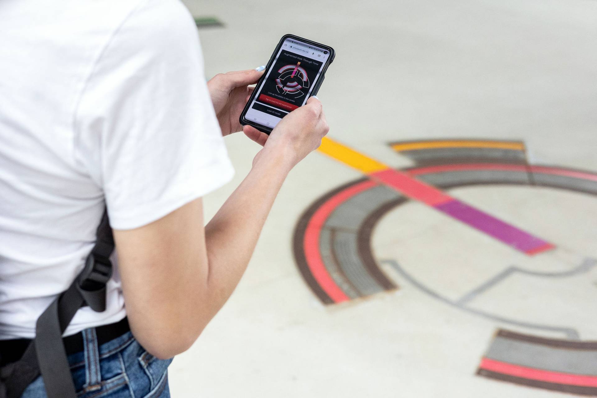Person using phone for more info on interactive exhibit