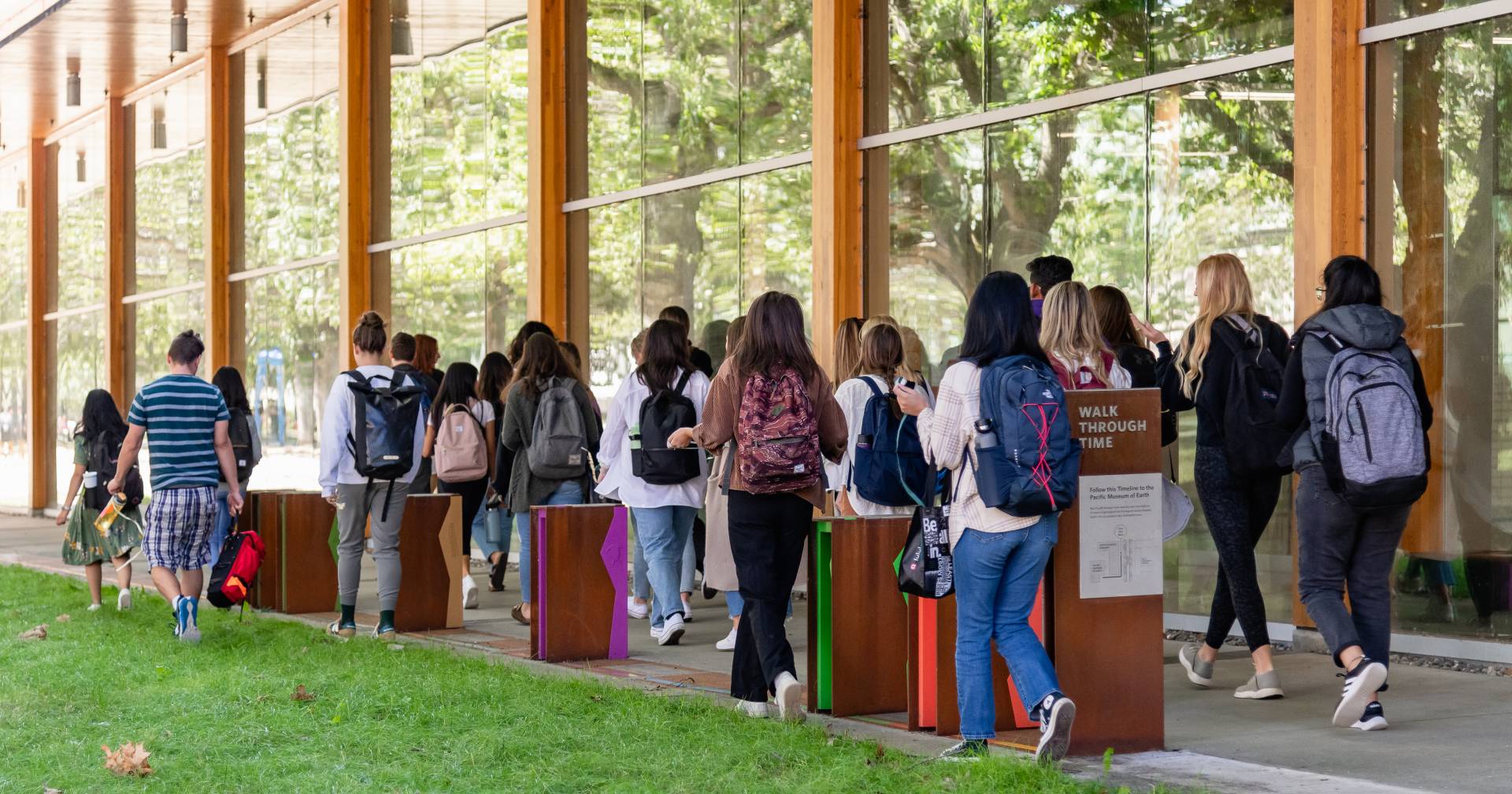 Students walking past exhibit